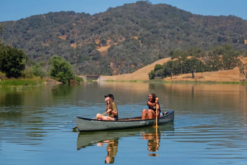 Dunn Summer School – Schülerinnen beim Kanufahren auf dem See des Dunn Summer School Campus