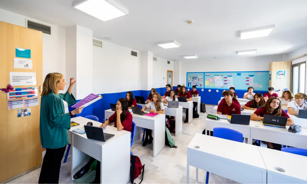 Sage College – Lehrerin unterrichtet eine Klasse aufmerksamer Schüler mit Laptops