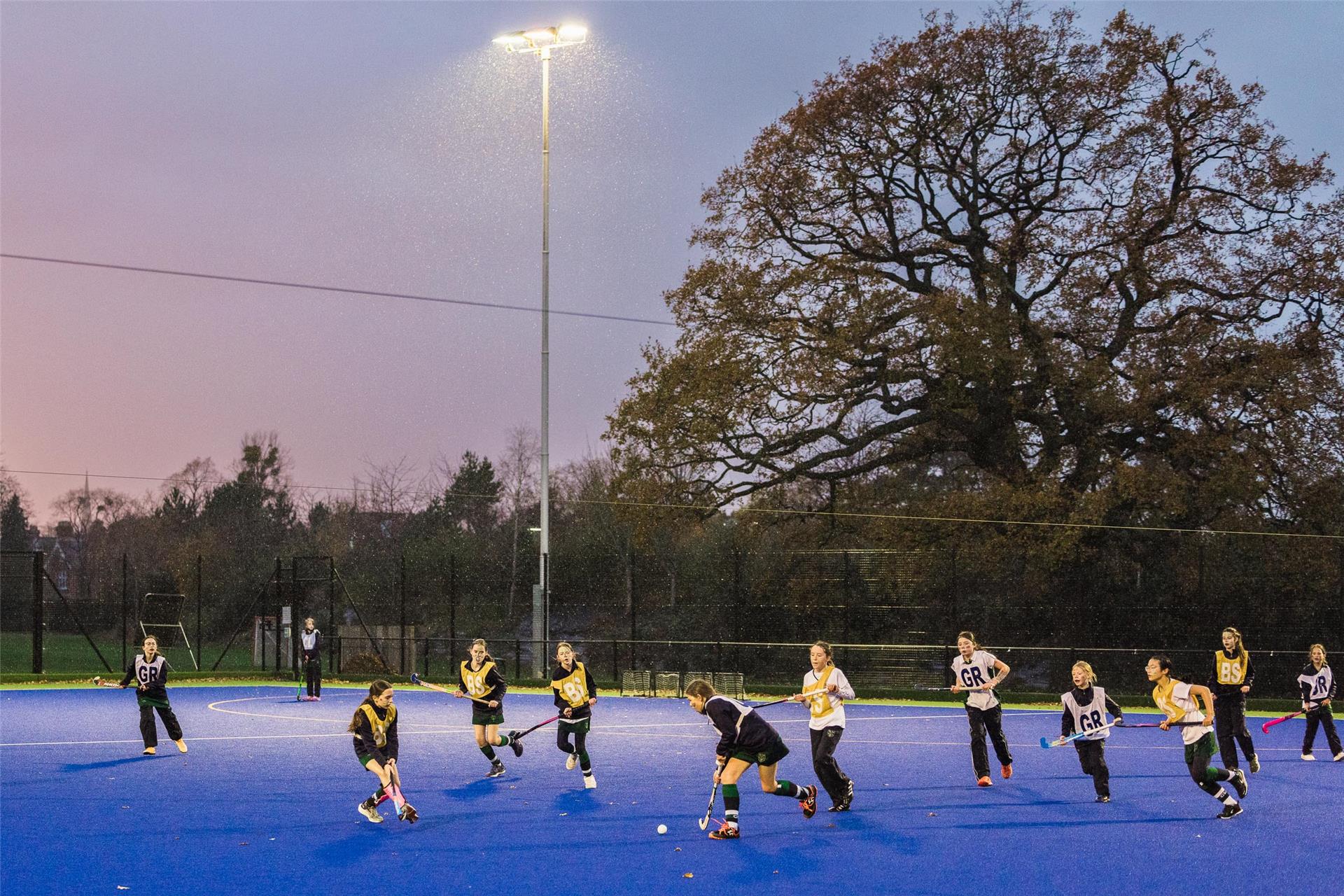 Schülerinnen des Cheltenham Ladies' College beim Feldhockey-Training auf dem Sportplatz bei Flutlicht