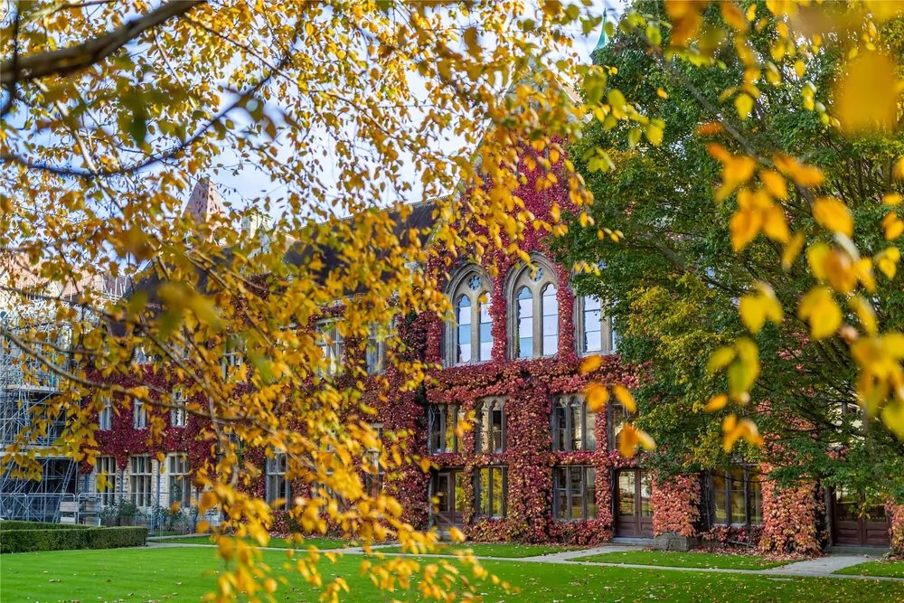 Historisches Hauptgebäude des Cheltenham Ladies' College im Herbst – efeubewachsene Fassade mit gotischen Bogenfenstern