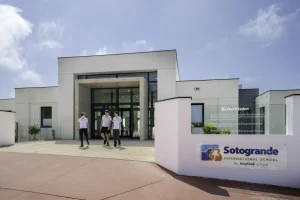 Schüler gehen am Eingang der Sotogrande International School unter einer Tafel mit dem Leitbild der Schule entlang
