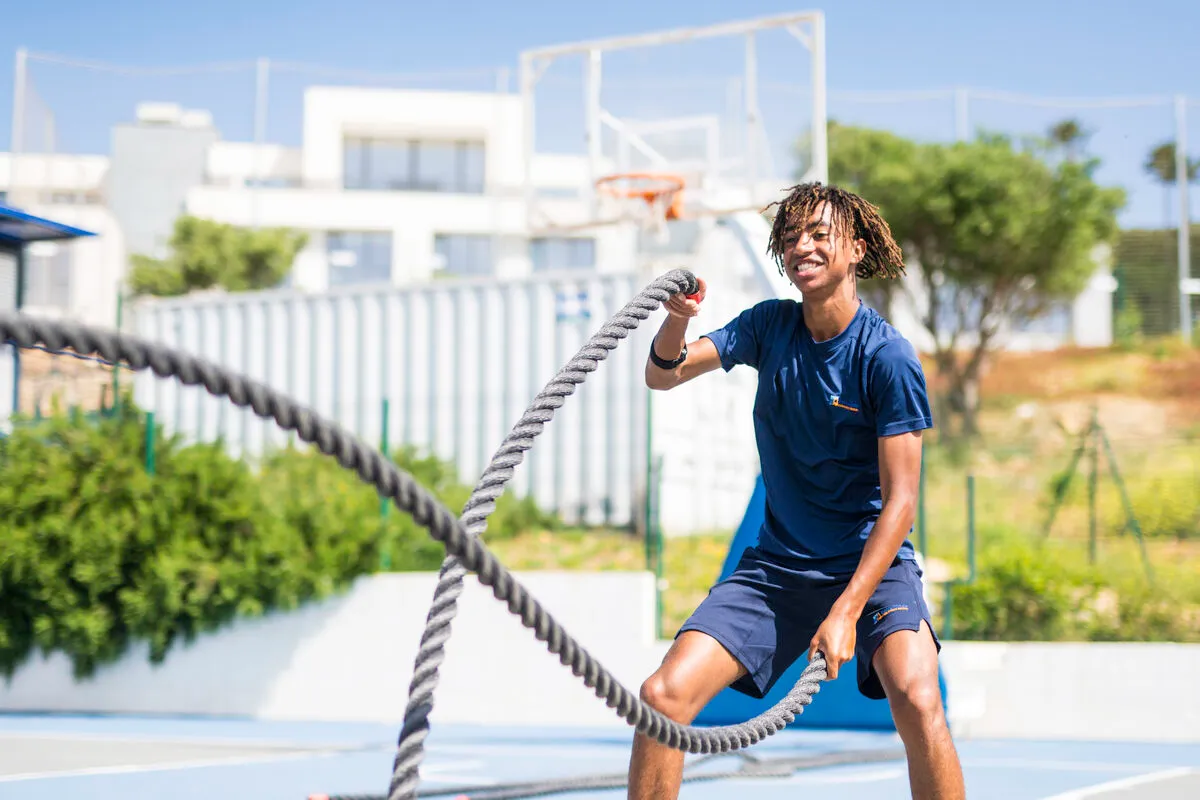 Schüler trainiert mit Battle Ropes auf dem Außensportplatz der Sotogrande International School