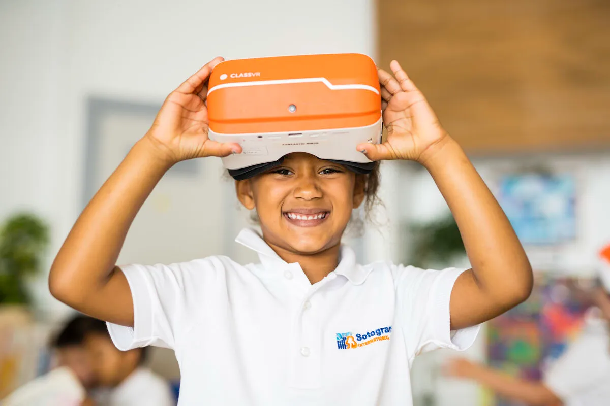 Schülerin der Sotogrande International School lächelt und hält sich eine VR-Brille über den Kopf
