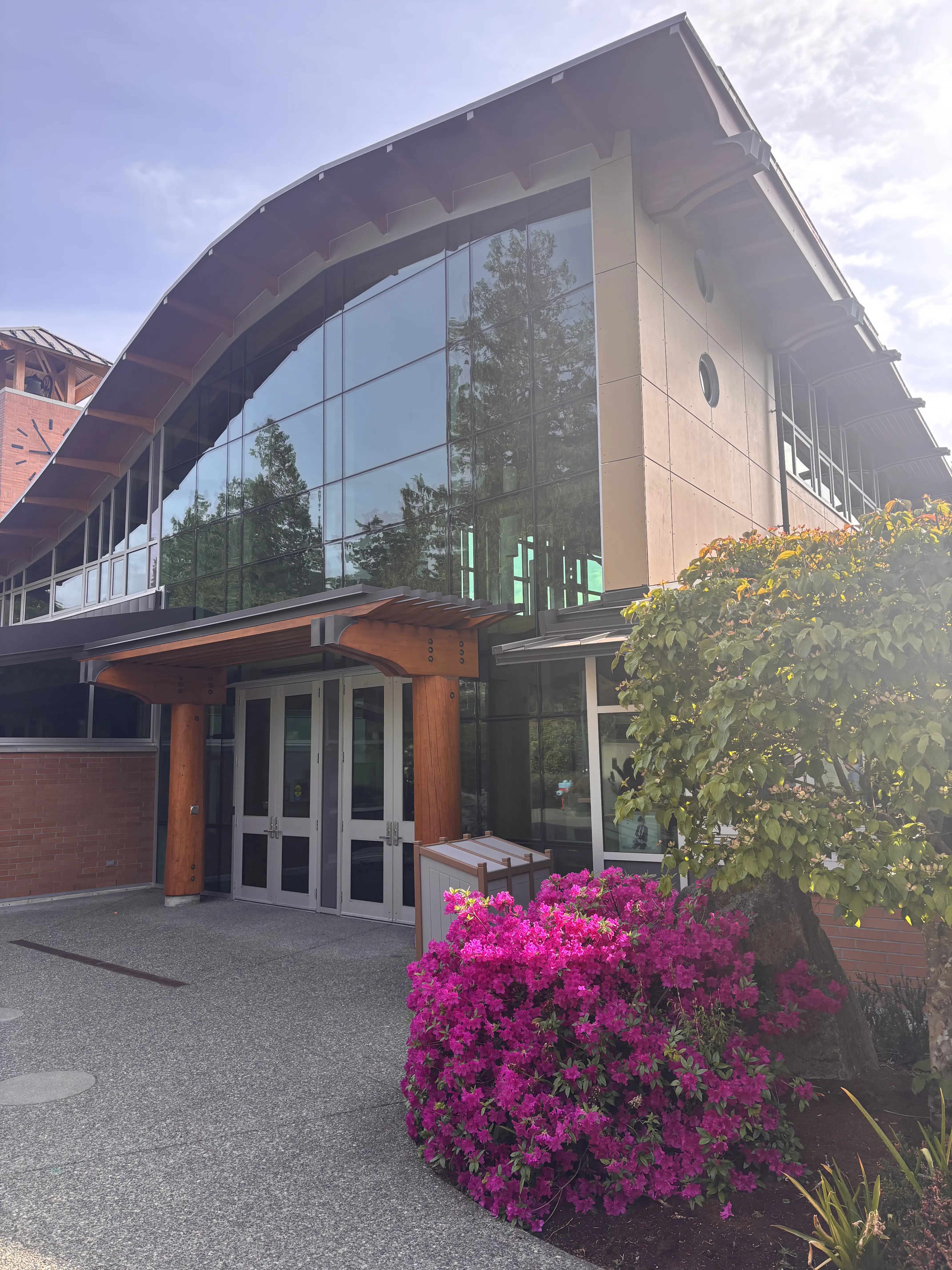 Brentwood College School – Moderner Eingangsbereich mit Glasfassade und blühenden Rhododendren