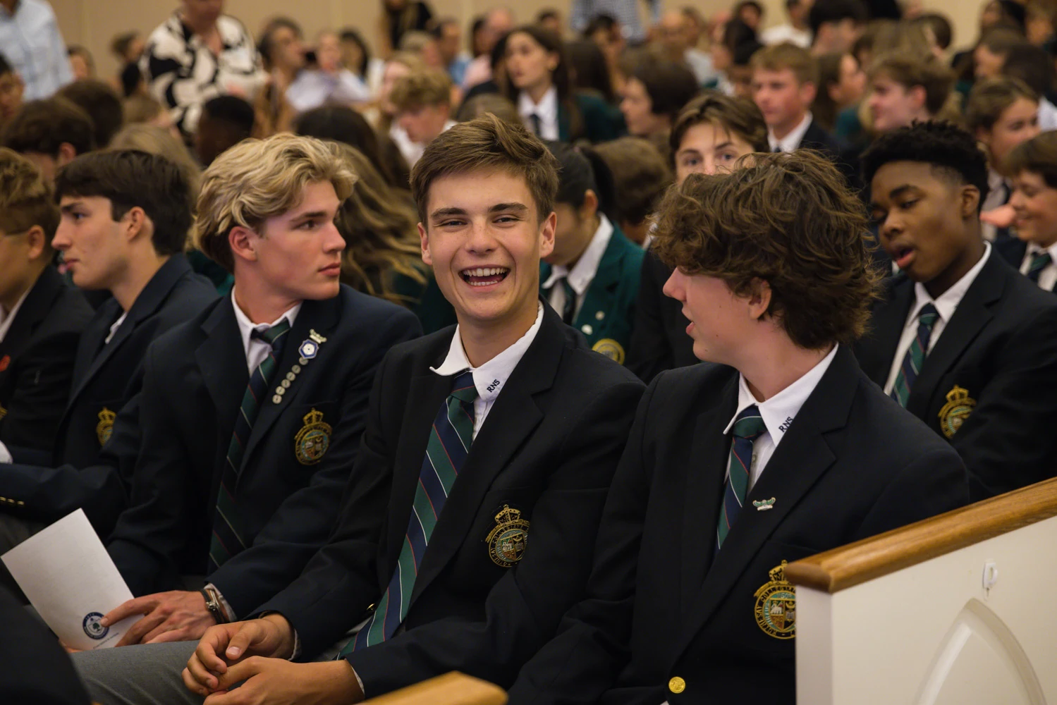 Rothesay Netherwood School – Lachende Schüler in Schuluniform bei einer Schulversammlung